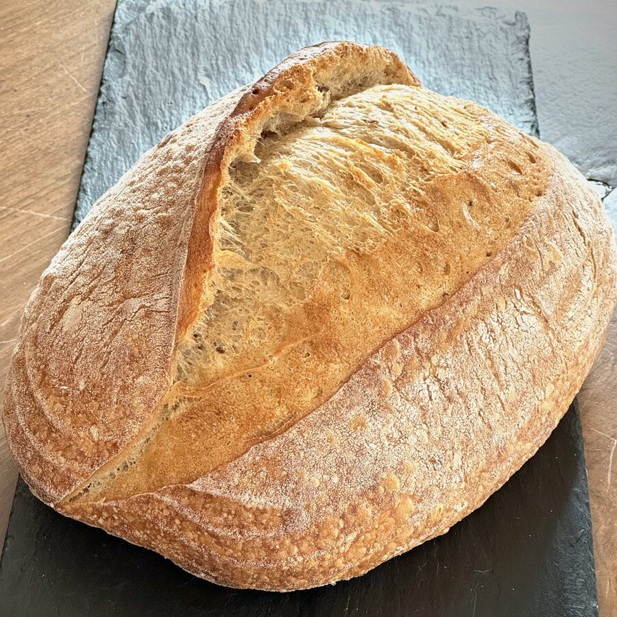 A scored sourdough loaf on slate — the strongest frame of the shoot